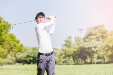 Asya adam golf oynuyor. Erkekler golf dururken sahada oynamak.