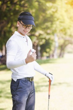 Asya adam golf oynuyor. Erkekler Golf gösterilen El sahada ayakta top