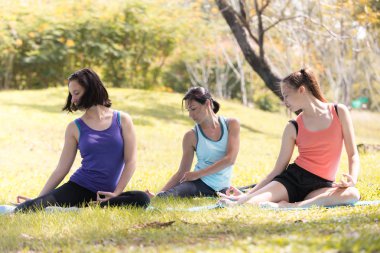 Tatil kadın Aile parkı spor sağlıklı kavramı poz meditasyon yoga yapıyor.