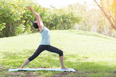 Yoga yapan tatilci kadın, halk parkında meditasyon yapıyor. Spor Sağlıklı Konsept..