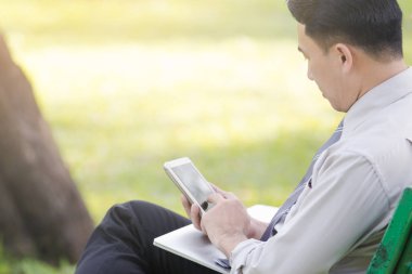 Asya iş erkek gevşeme Park smartphone ile çalışmak