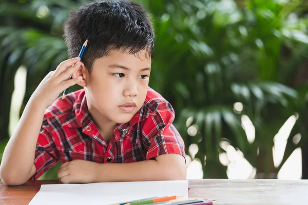 Asyalı küçük çocuk beyaz kağıda yazı renk kalem kullanın