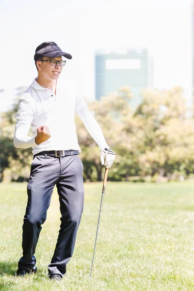 Asian men playing golf. Men play hole in one golf while standing on field