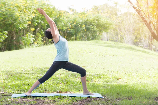 Yoga yapan tatilci kadın, halk parkında meditasyon yapıyor. Spor Sağlıklı Konsept..