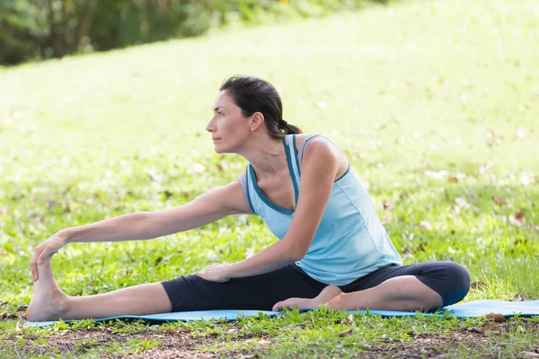 Yoga yapan tatilci kadın, halk parkında meditasyon yapıyor. Spor Sağlıklı Konsept..