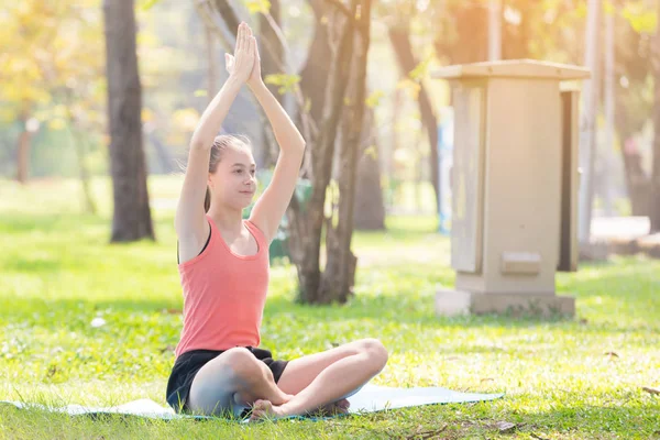 Tatil genç kadının Yoga poz meditasyon Parkı spor sağlıklı kavramında yapması.