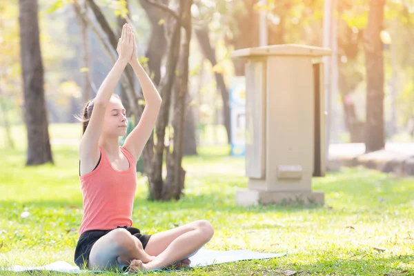 Tatil genç kadının Yoga poz meditasyon Parkı spor sağlıklı kavramında yapması.