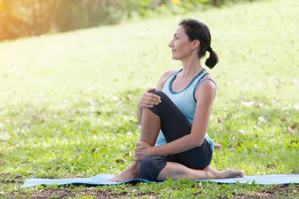 Yoga yapan tatilci kadın, halk parkında meditasyon yapıyor. Spor Sağlıklı Konsept..
