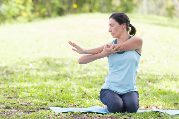 Yoga yapan tatilci kadın, halk parkında meditasyon yapıyor. Spor Sağlıklı Konsept..