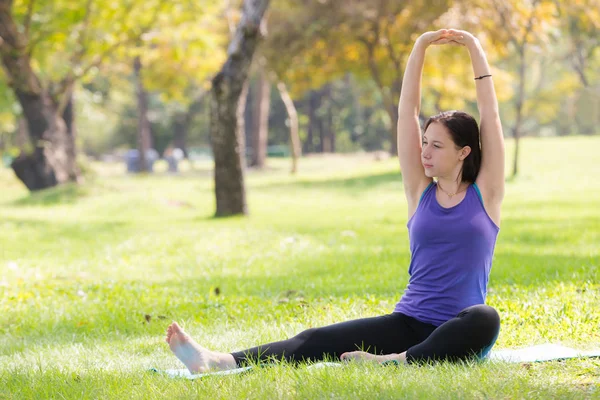 Tatil genç kadının Yoga poz meditasyon Parkı spor sağlıklı kavramında yapması.