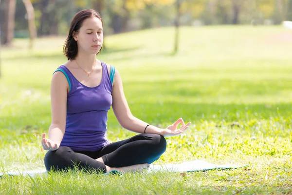 Tatil genç kadının Yoga poz meditasyon Parkı spor sağlıklı kavramında yapması.