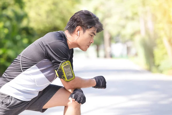 Fitness spor genç adam runner parkta germe egzersiz yapmak. Sağlıklı kavramı