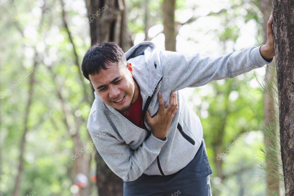 Asian cardiac arrest running young man heart attack in park.Severe heartache