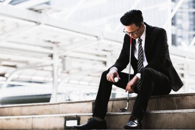 Golf kulüpleri iş adamları tutun ve golf topları şehirde üzgün oturmak.