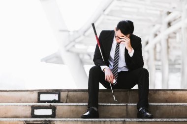 Golf kulüpleri iş adamları tutun ve golf topları şehirde üzgün oturmak.