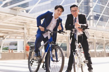 Şehirde bisiklet sürme sırasında konuşurken Asya yakışıklı genç iş adamları