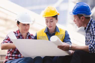 Şehirde bina inşaat mühendisleri erkek ve kadın üzerinde çalışma planı