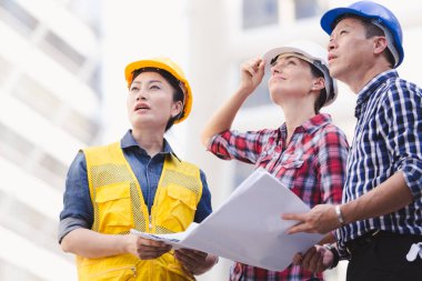 Şehirde bina inşaat mühendisleri erkek ve kadın üzerinde çalışma planı