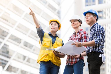 Şehirde bina inşaat mühendisleri erkek ve kadın üzerinde çalışma planı