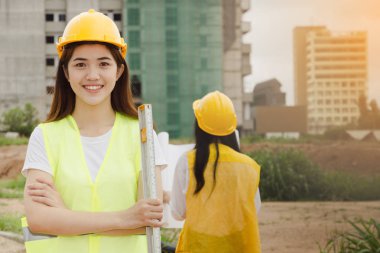 Bina inşaat sitesindeki kağıt ile plan üzerinde çalışan mühendisler Asya iki kadın