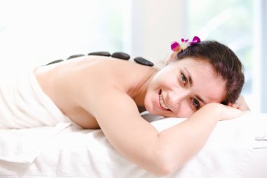 Spa salonu beyaz ışık arka plan, taş vücut, Spa kavramı üzerinde rahatlatıcı güzel genç kadın