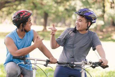 Portre Asya iki genç adam binicilik bisiklet Park, adam yaşam tarzı konsept spor