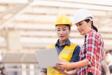 Bina inşaat şehir içinde laptop ile plan üzerinde çalışan iki kadın mühendisler