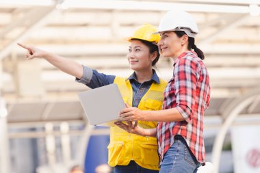 Bina inşaat şehir içinde laptop ile plan üzerinde çalışan iki kadın mühendisler