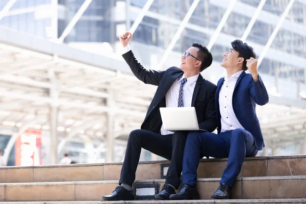 Asyalı iki işadamları oturan şehir içinde laptop üzerinde çalışıyoruz
