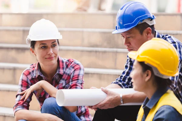 Şehirde bina inşaat mühendisleri erkek ve kadın üzerinde çalışma planı