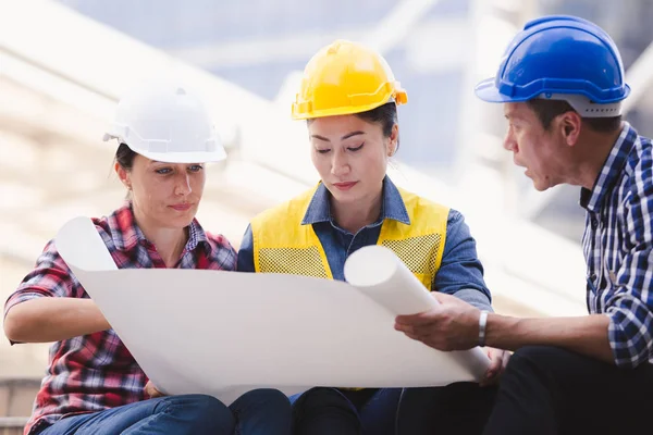 Şehirde bina inşaat mühendisleri erkek ve kadın üzerinde çalışma planı