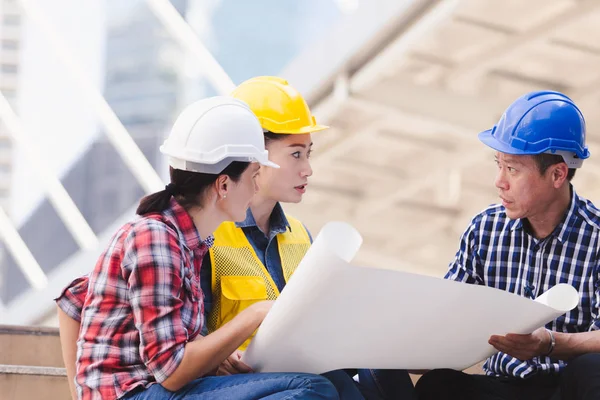 Şehirde bina inşaat mühendisleri erkek ve kadın üzerinde çalışma planı