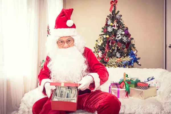 Santa Claus holds gift in hand, there is money in the gift,christmas concept