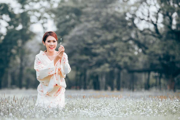 Doğal yeşil çim bir kimono giyen Asyalı Genç kız.