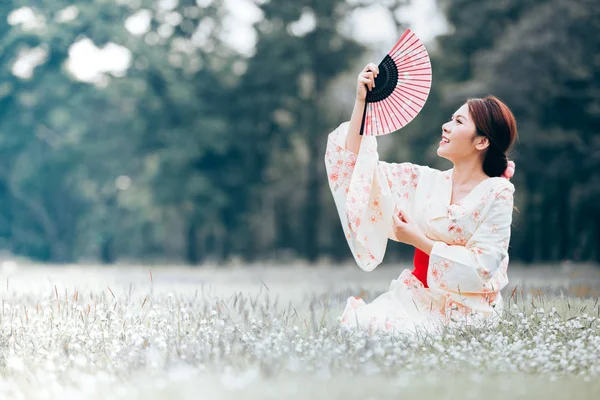 Doğal yeşil çim bir kimono giyen Asyalı Genç kız.