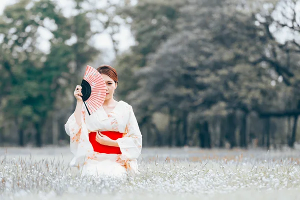亚洲年轻女孩穿着和服在自然绿草 — 图库照片