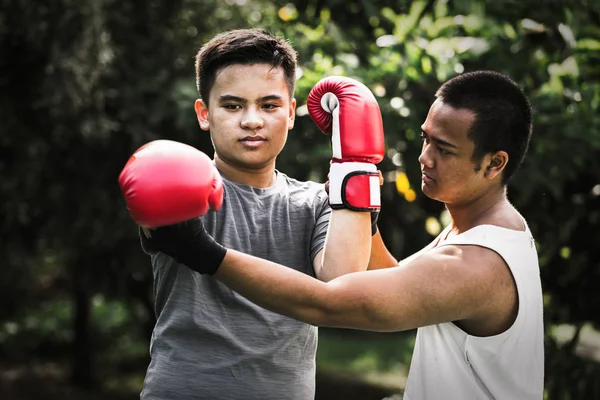 Asian young men with personal trainer boxing friend, Boxing gloves