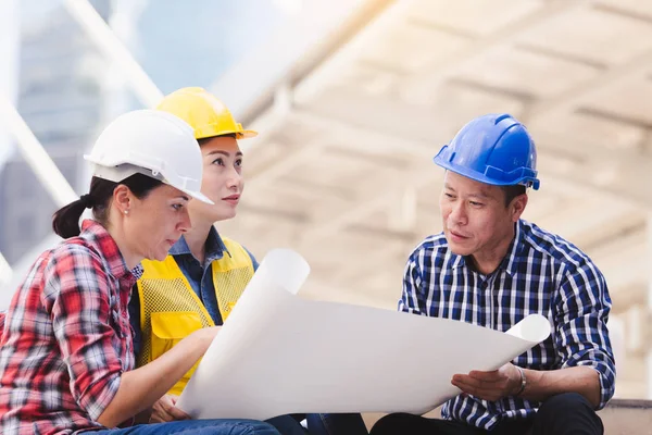 Şehirde bina inşaat mühendisleri erkek ve kadın üzerinde çalışma planı