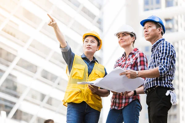 Şehirde bina inşaat mühendisleri erkek ve kadın üzerinde çalışma planı