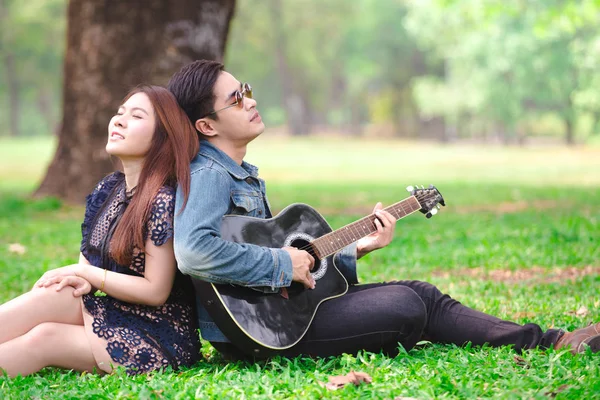 Asiatico Coppia Amore Giocare Acustica Canzone Chitarra Seduta Erba Parco — Foto Stock