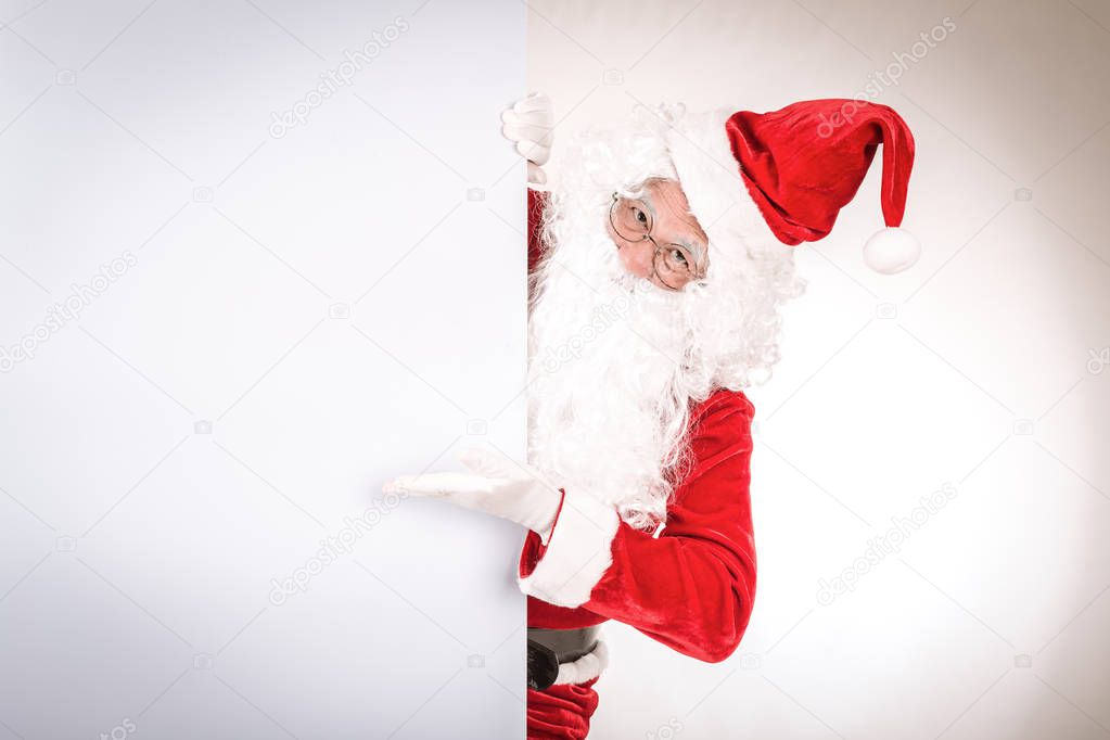 Merry christmas,Santa Claus pointing in white blank sign