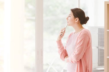 İş kadını ayakta çalışma bir pencere yakınında ve office telefonla konuşurken telefon tutarak.