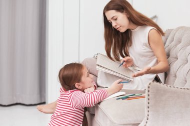 Yatak odasında birlikte aile mutlu anne ve kızı ile renkli kalemler çizim yaptırın
