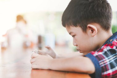 Asyalı küçük çocuk oturan bir akıllı telefon, teknoloji ve insan kavramı ile oyun online oyun