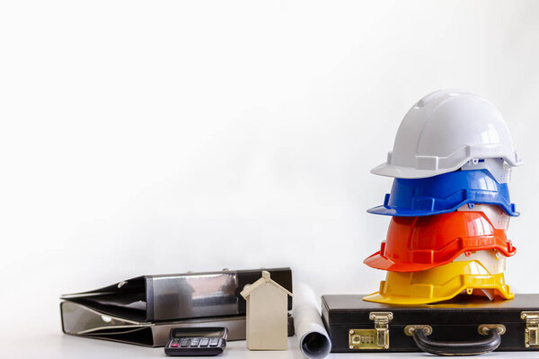 Safety helmet on table in office , engineer concept Teamwork of building construction