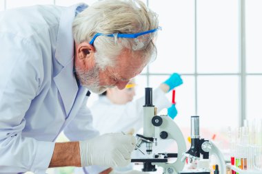 Laboratuvarda mikroskop kimyasalları ile çalışan bilim adamları