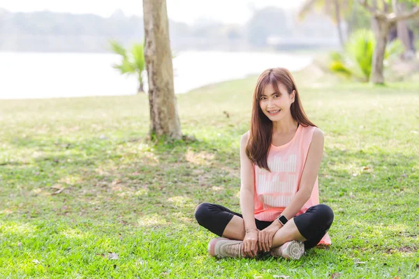 Азиатская красивая молодая женщина расслабляющая упражнения в парке — стоковое фото