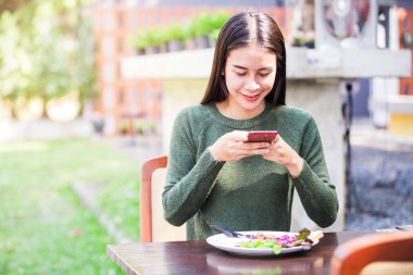 Kahvaltı nın fotoğrafını çeken Asyalı genç kadın