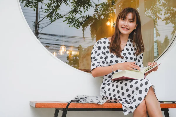 Güzel Asyalı genç kadınlar kitap açık okuma oturuyor