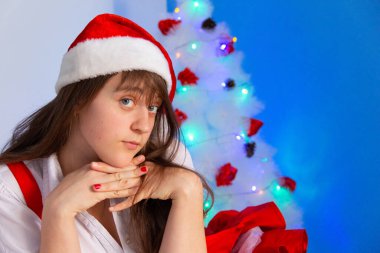 Noel ağacının yanında flört eden genç bir kadın gülümsüyor.